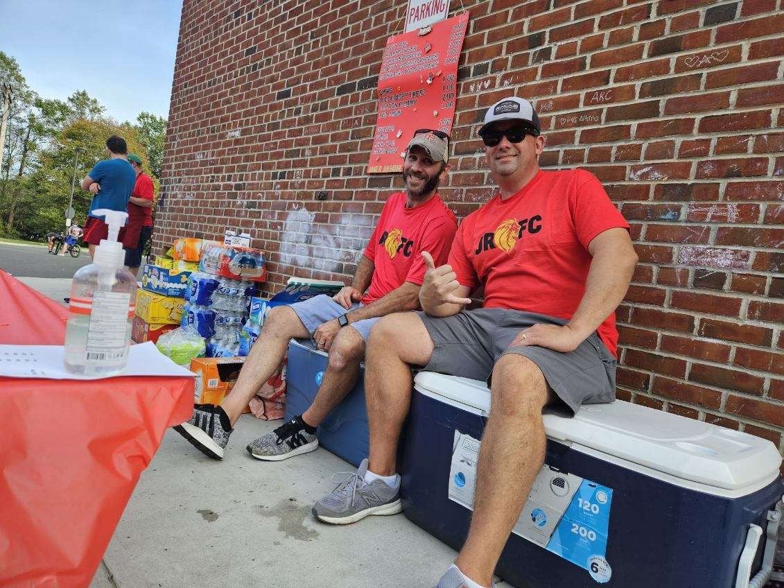 Fathers Club members seated on coolers at the Back to School BBQ